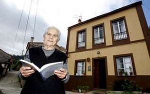 Rosa Vila, sobriña política de Áurea Lorenzo Abeijón, sostén a reedición de «Queixas» fronte á súa casa, na cal nacera no 1904 a poetisa. Foto: C. Queijeiro.