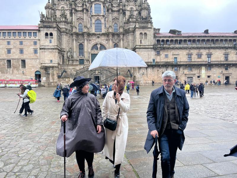 Imagen de la llegada a la Praza do Obradoiro de las y los miembros de la Irmandade Galega de Rubí que peregrinaron a Compostela