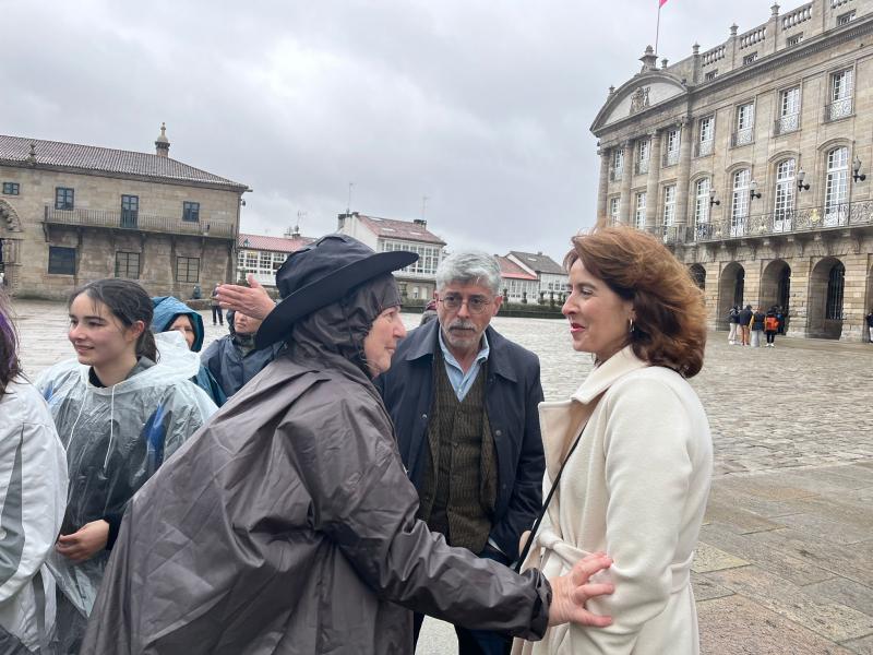 Imagen de la llegada a la Praza do Obradoiro de las y los miembros de la Irmandade Galega de Rubí que peregrinaron a Compostela